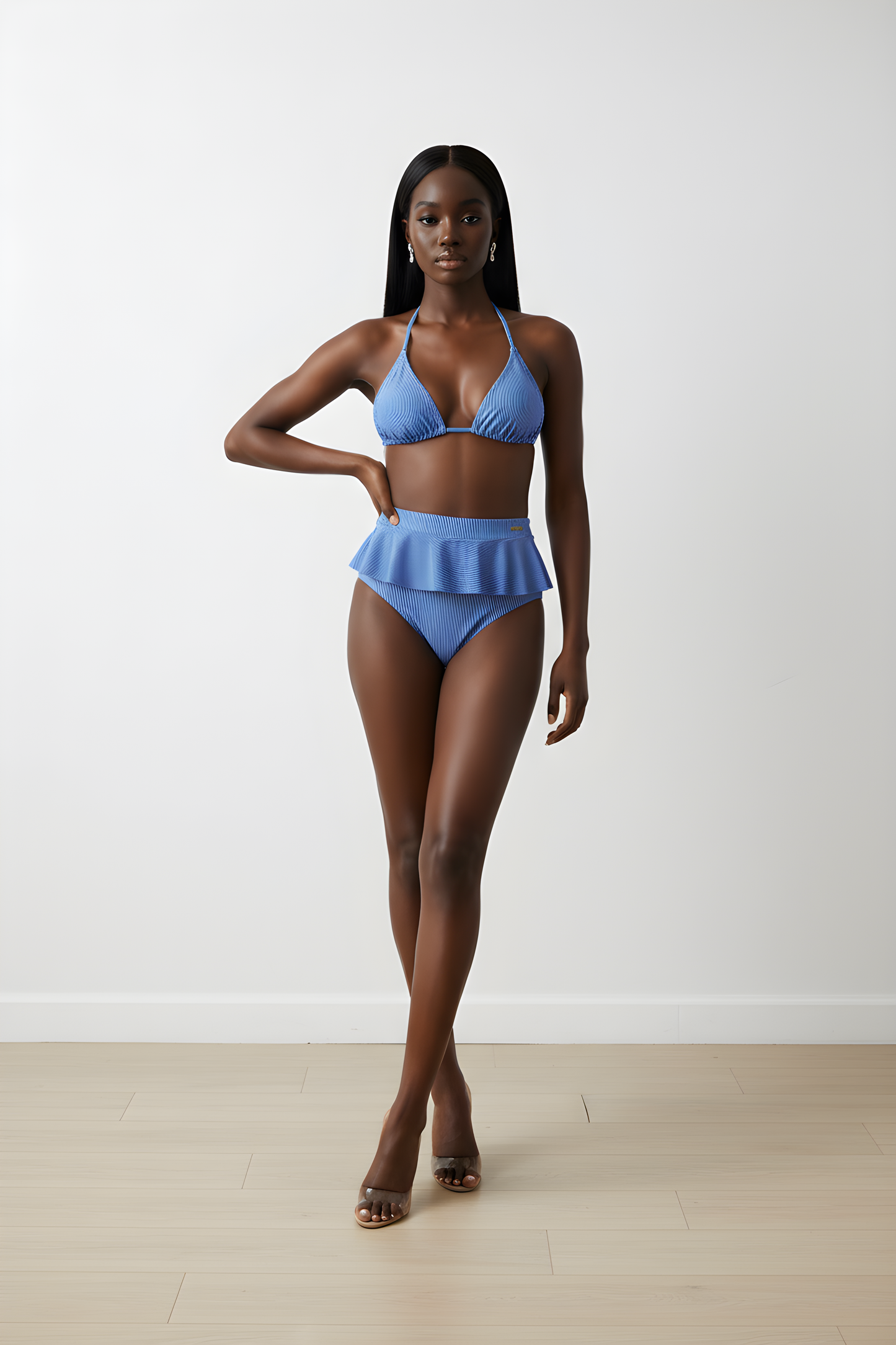 Full-length studio photography of a model wearing the Chryssi luxury pinstripe bikini set, featuring a classic adjustable triangle halter top paired with high-waisted swimwear bottoms and a dramatic fluid peplum ruffle.