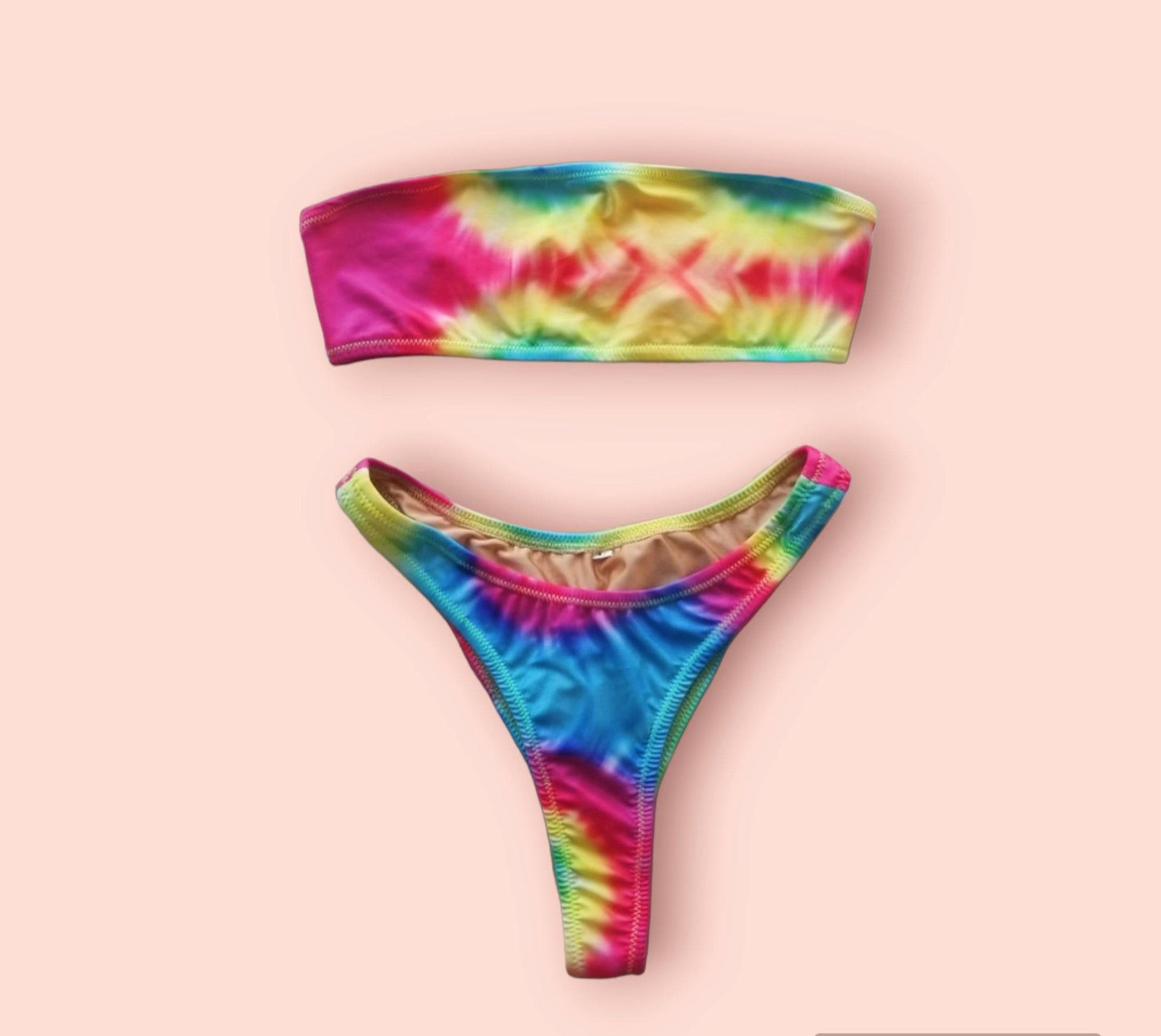 Front view of the actual Solaris tie-dye bikini top laying flat, showing the vibrant orange, blue, and purple fabric tones.
