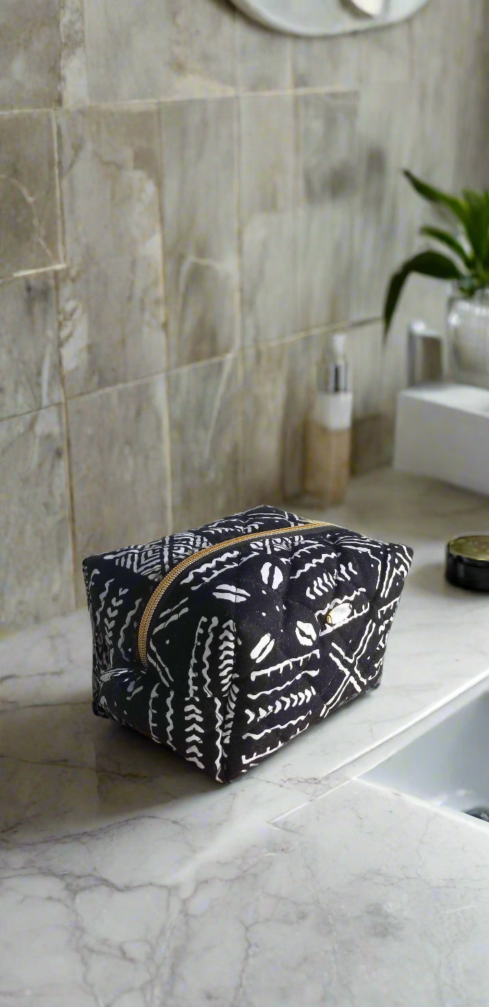 Side view of the Scope and Flow Tribal Noir toiletry bag, showcasing the textured African print fabric and structured design.