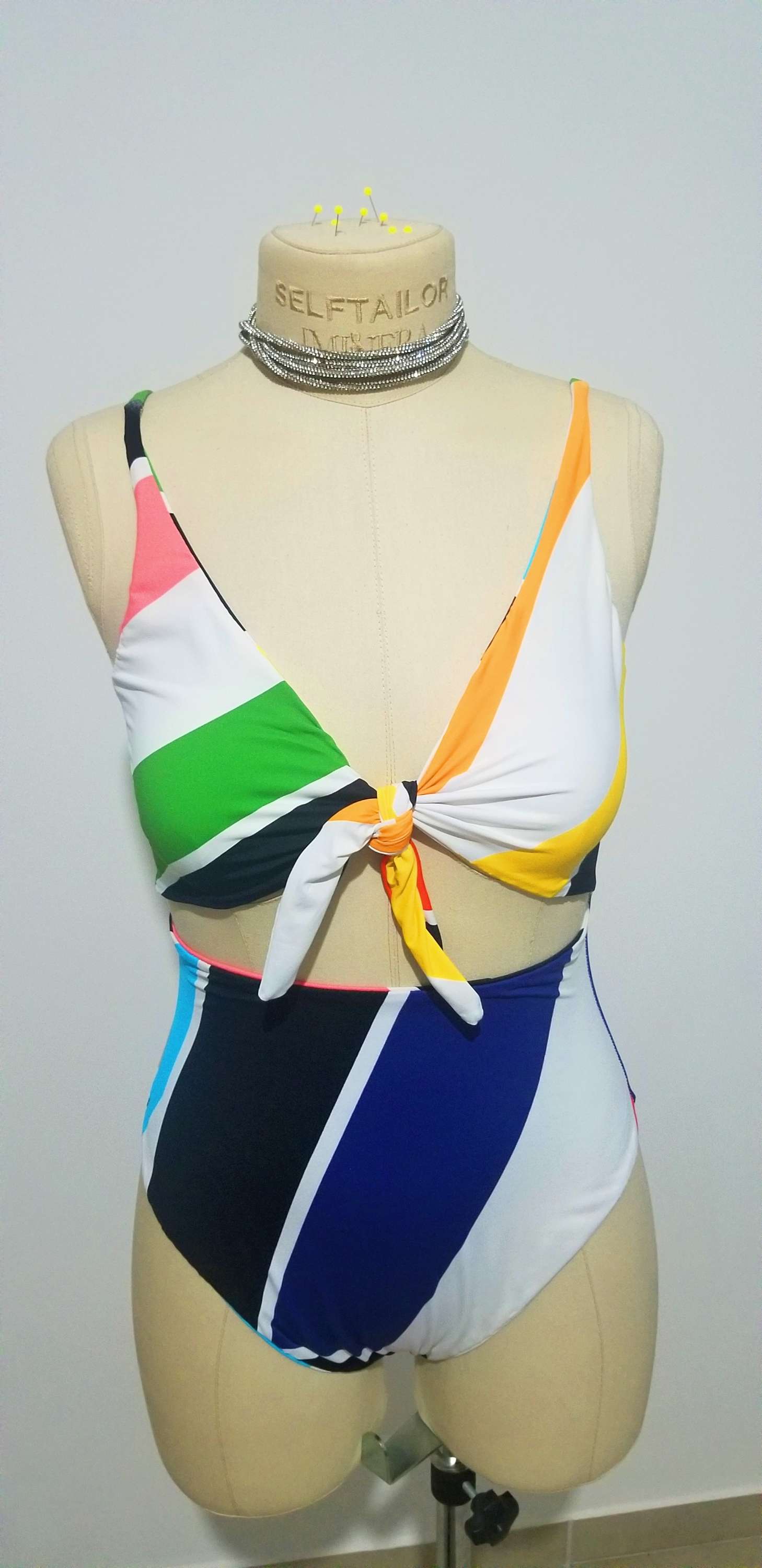 a female mannequin wearing a multicolored swimsuit