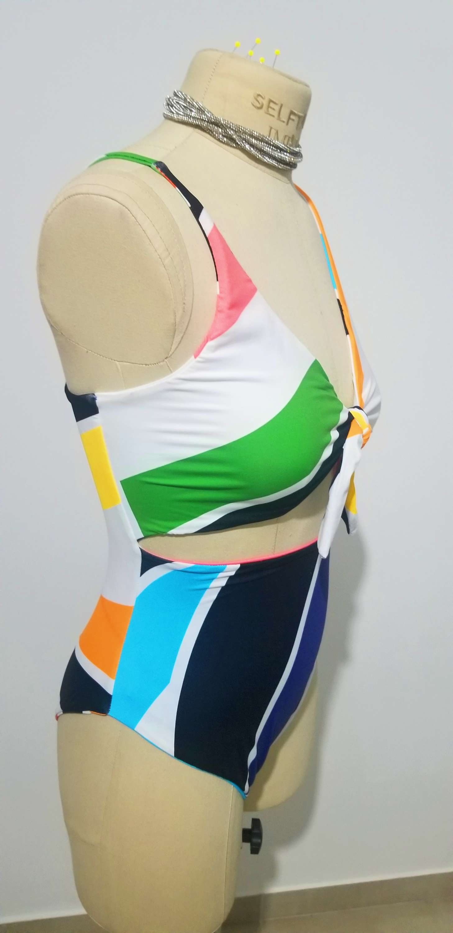 a female mannequin wearing a multicolored one piece swimsuit