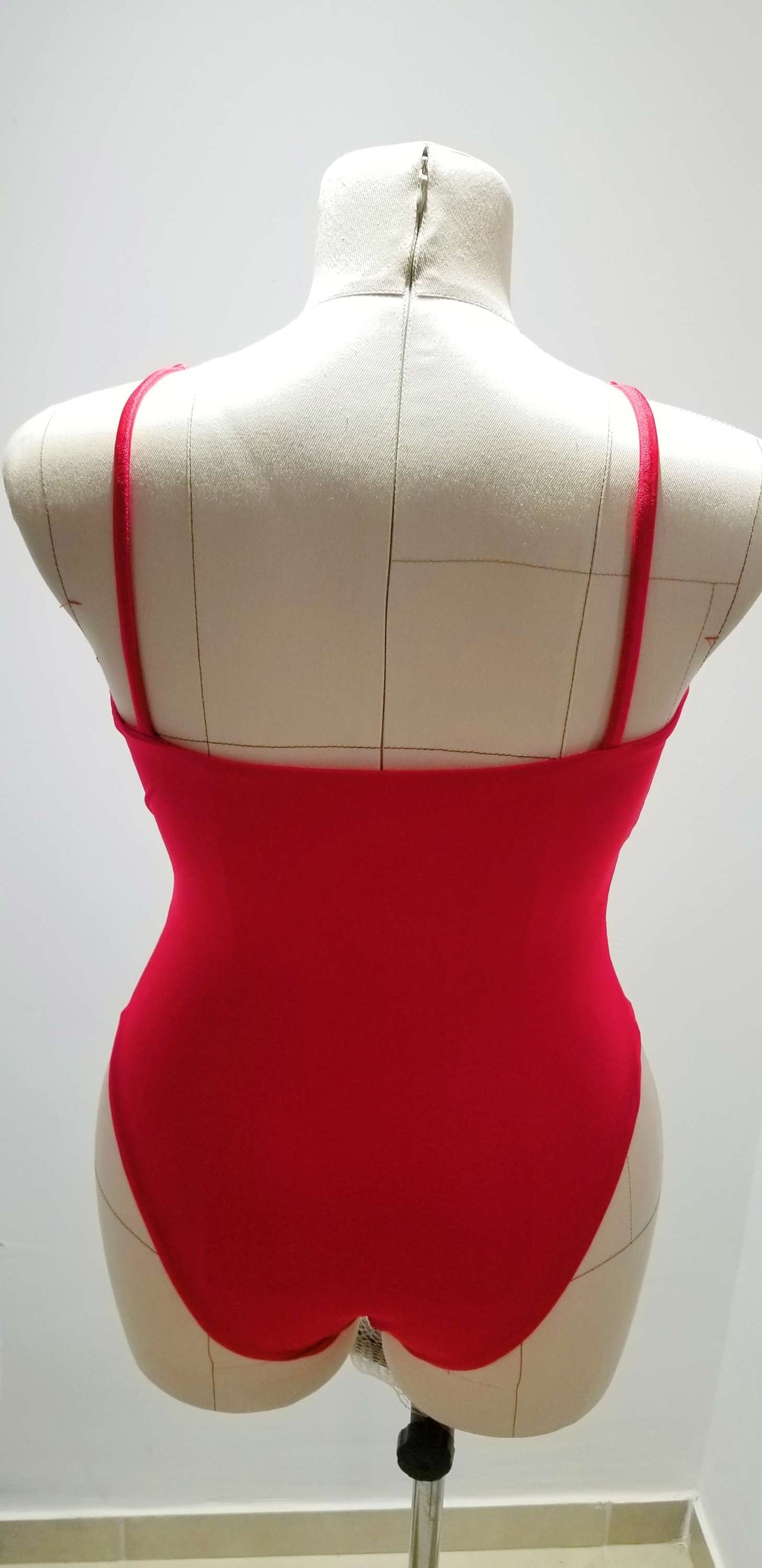 a white mannequin with a red top on display