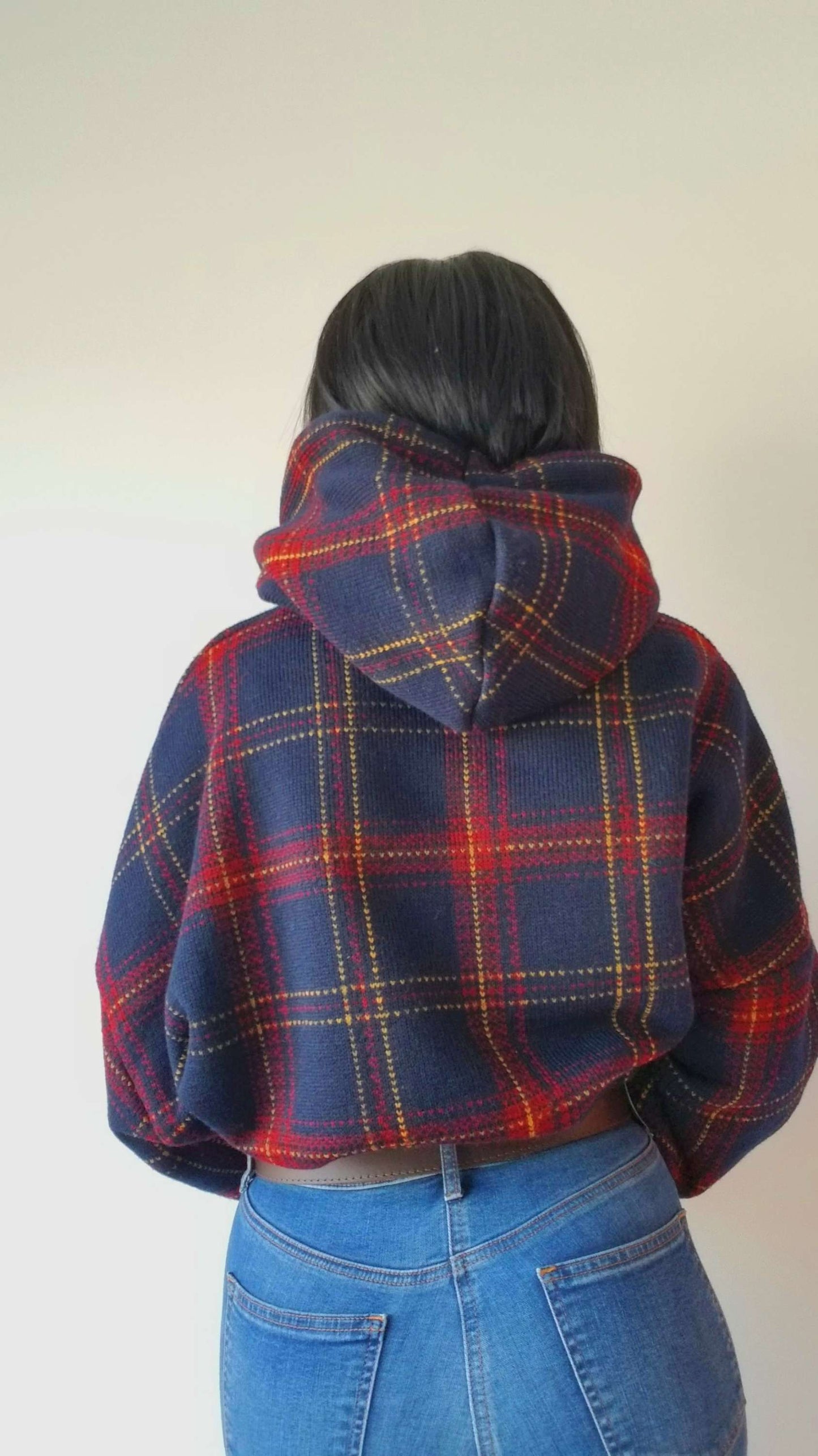 a woman wearing a blue and red plaid jacket