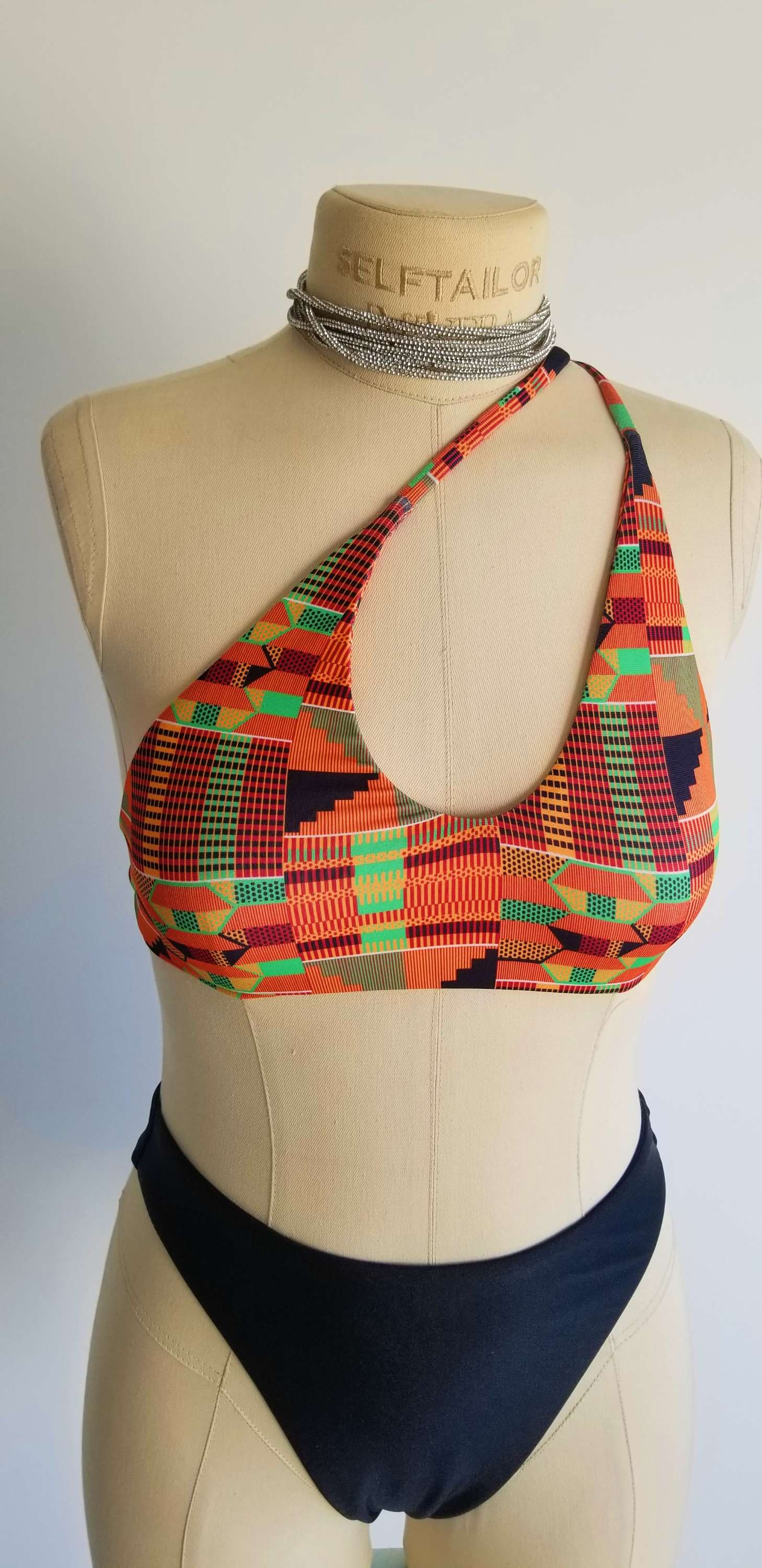 A styling guide for the Scope and Flow African print top, showing the different ways to wrap the straps and a detailed back view.
