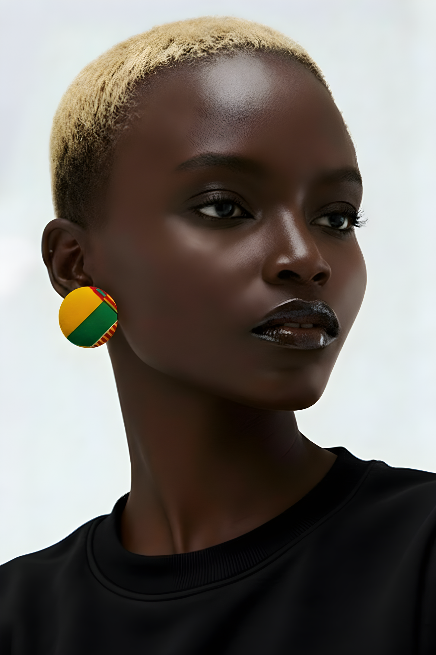 Oversized fabric-covered stud earrings featuring a bold yellow, green, and red geometric African print.