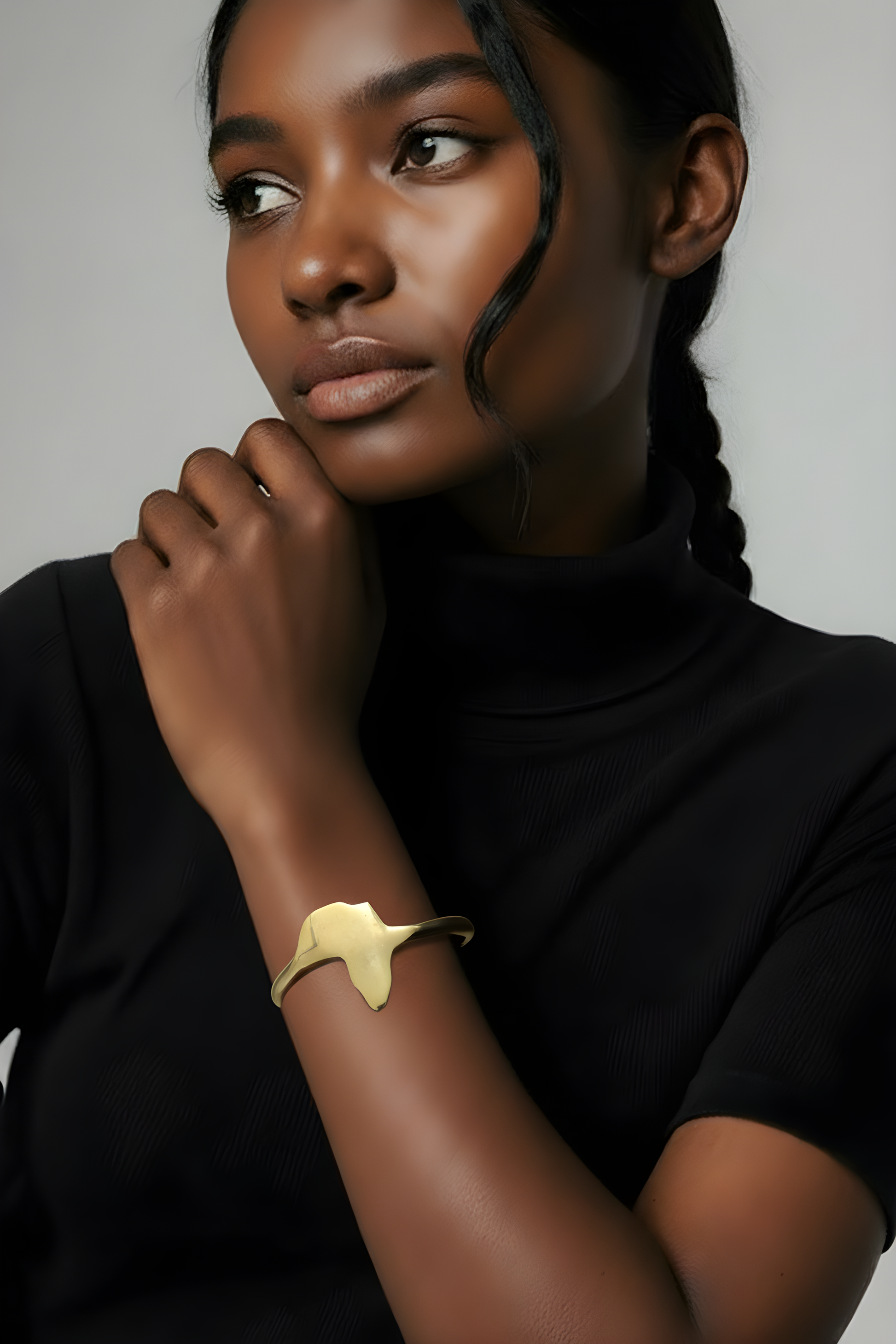 Editorial close-up of a model wearing the Scope and Flow gold Continent Cuff against a black turtleneck, showcasing a minimalist luxury aesthetic.