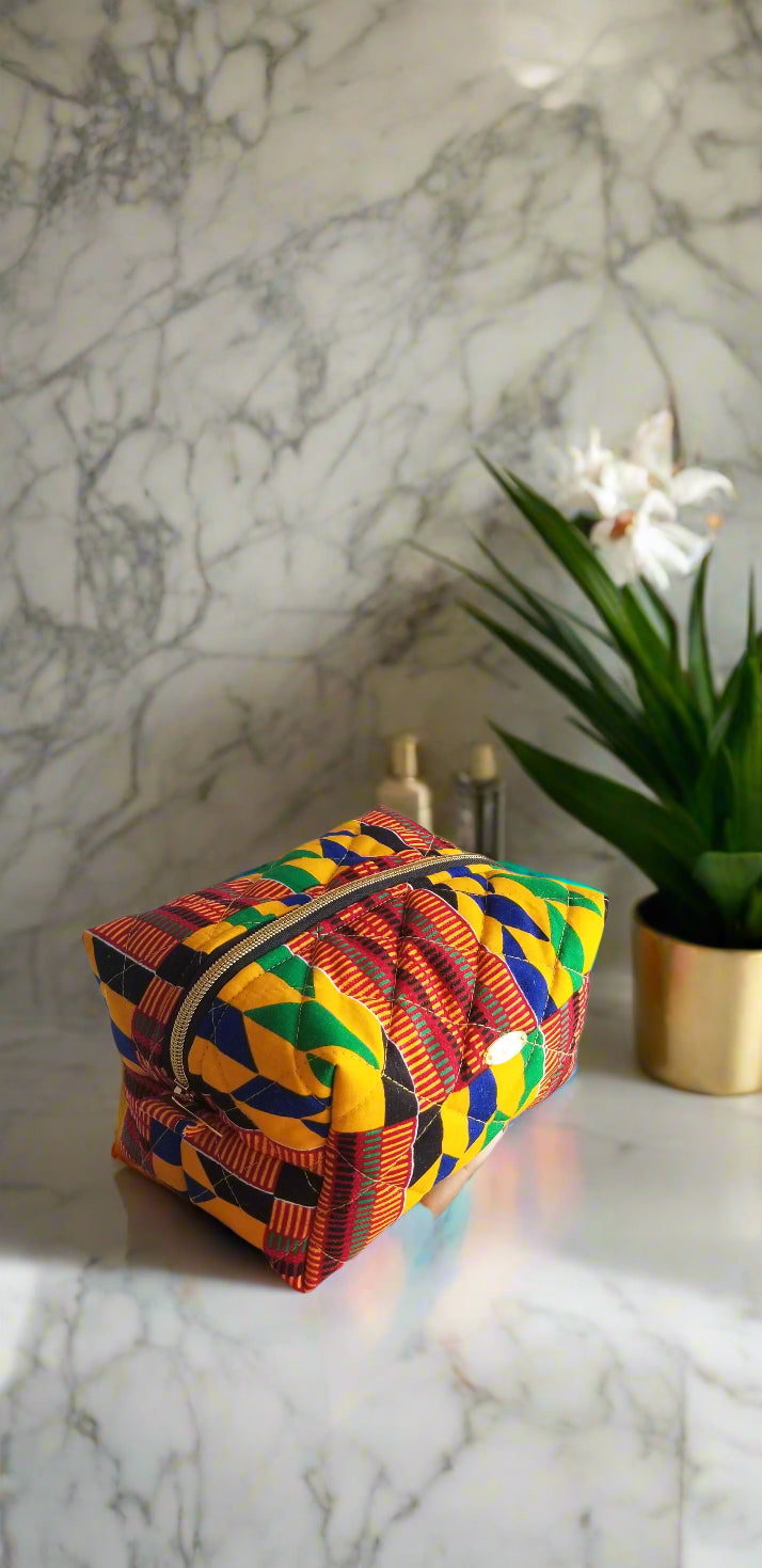 Front view of the Crimson Tribal red and white makeup bag by Scope and Flow on a marble vanity.