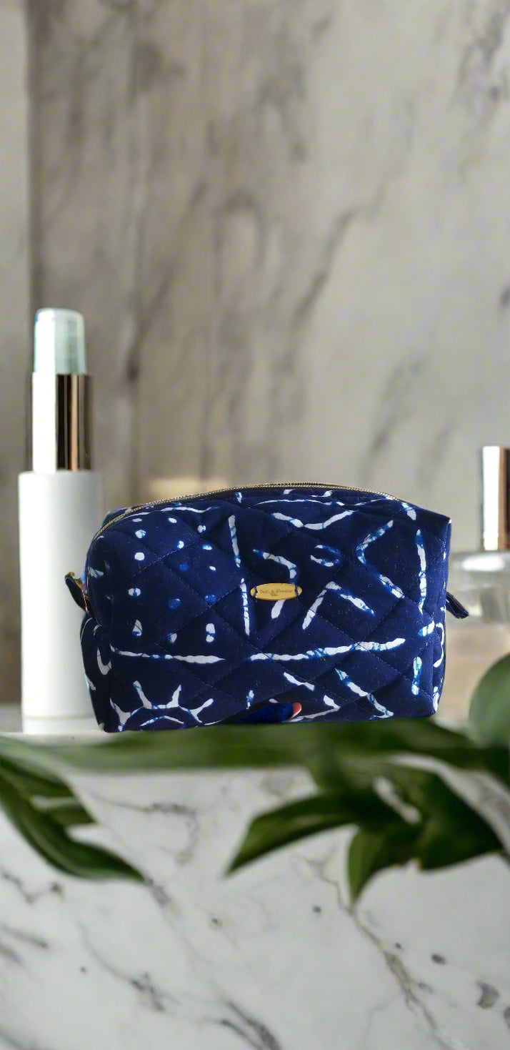 Close-up of the deep indigo and white geometric tribal pattern on the Scope and Flow makeup bag. 