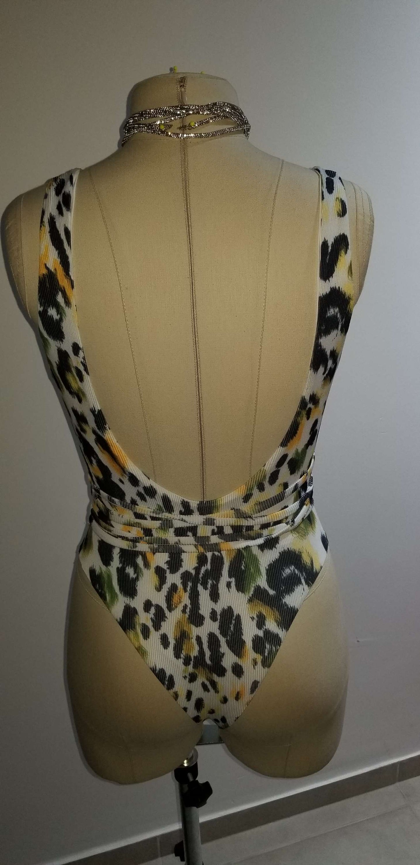 A mirror-selfie of a model wearing the high-cut green and gold leopard print bodysuit, showing the true fit and flattering silhouette.