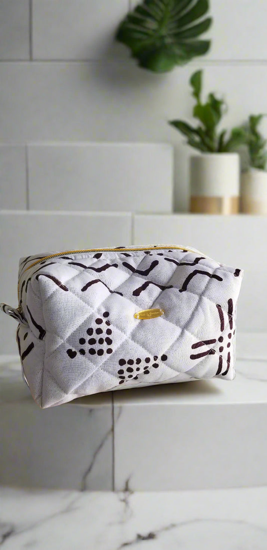 Front view of the Ethereal Monochrome black and white makeup bag by Scope and Flow on a marble vanity.