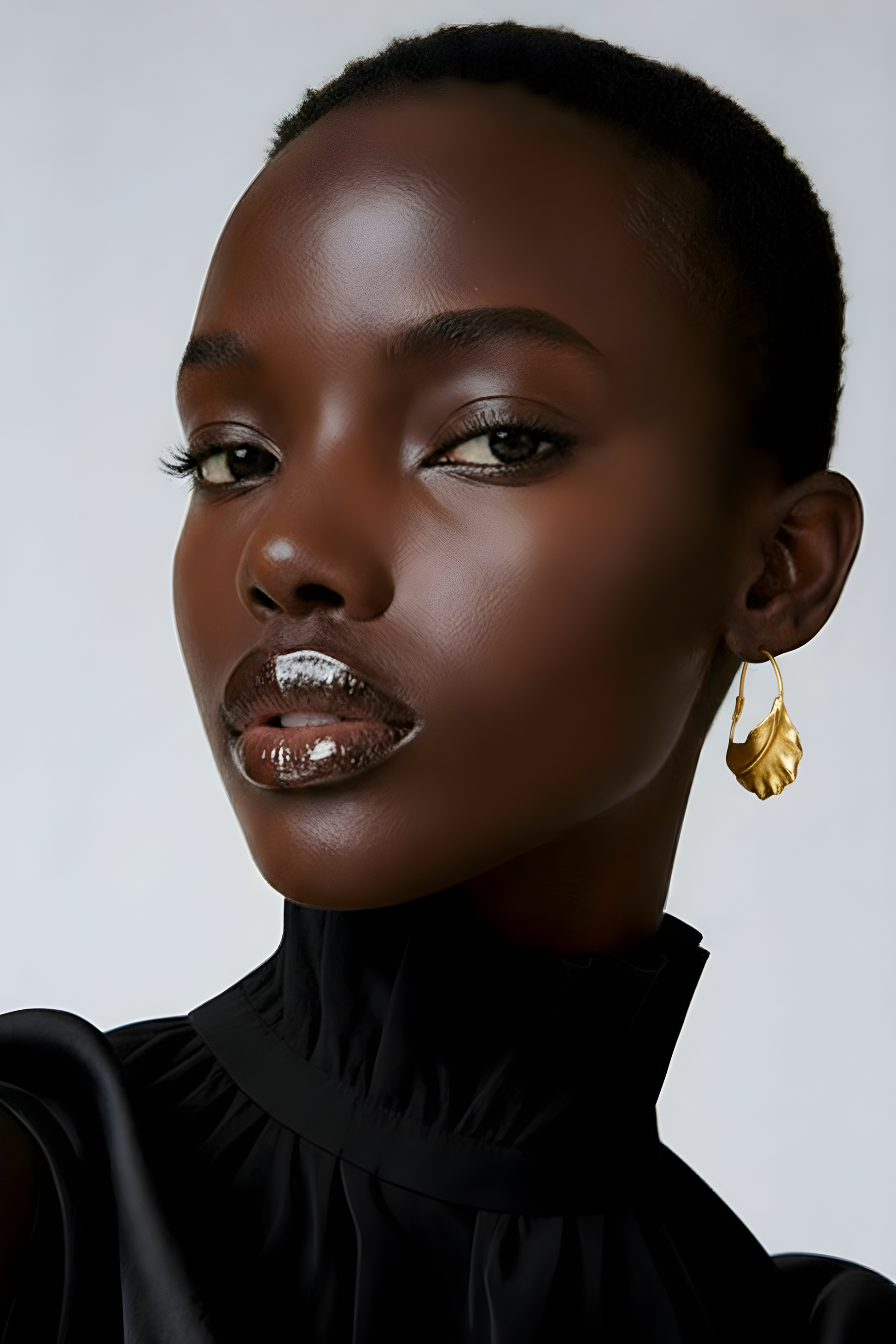 Model wearing the Scope and Flow Fulani Twist Hoop earrings, showing the traditional tapered gold design.