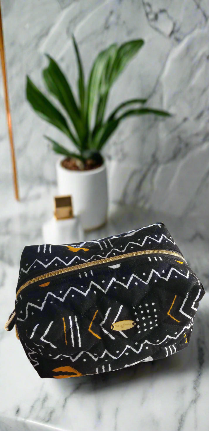 Angled side view of the Scope and Flow gilded makeup bag, showing the structured design and luxury bathroom styling.