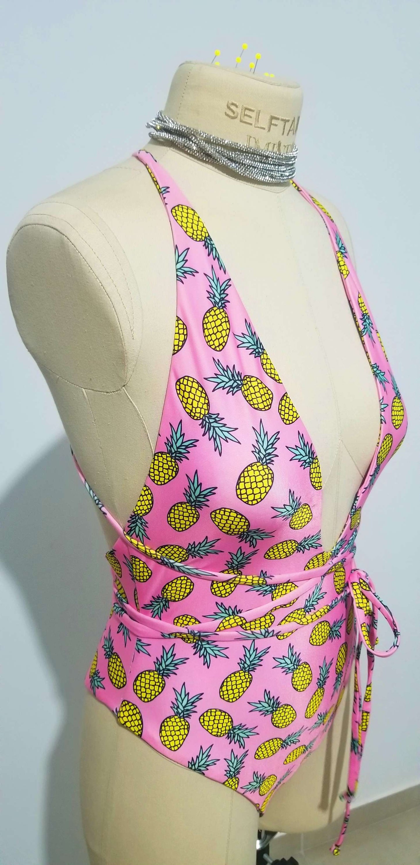 Close-up of the long-tie back variation on the Helix bodysuit, showing the customizable wrap-around straps.