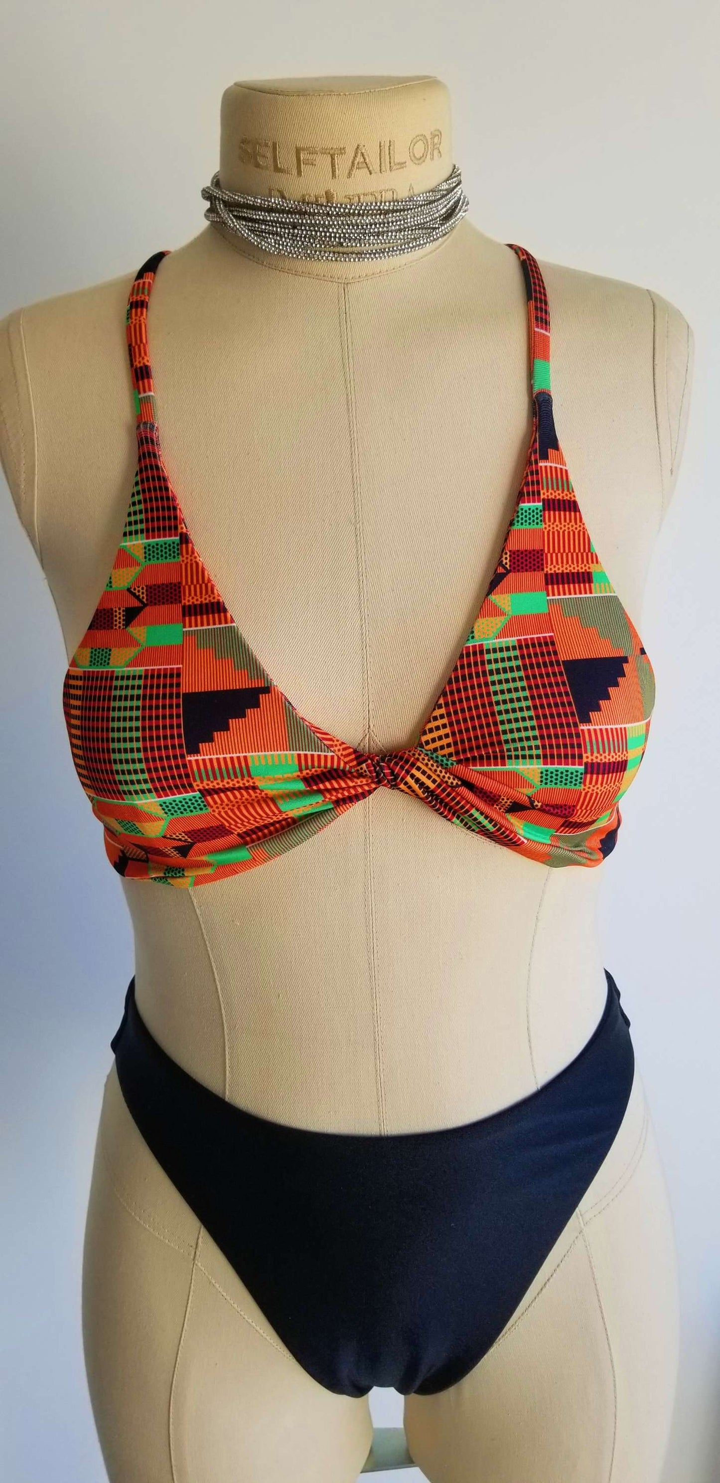 Close-up detail of the vibrant, multicolored African print fabric and premium stitching on the Scope and Flow Heritage Infinity top.