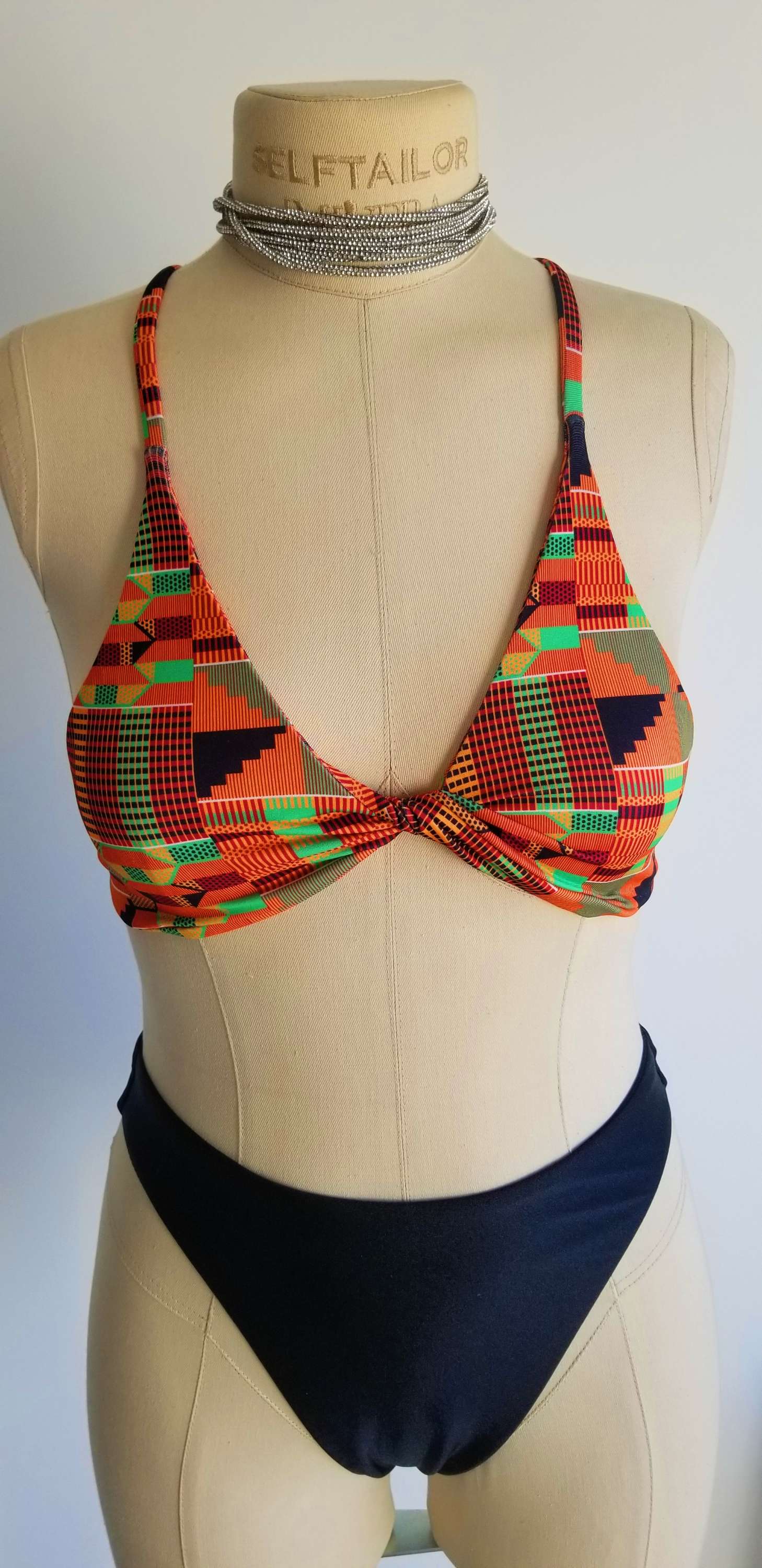 Close-up detail of the vibrant, multicolored African print fabric and premium stitching on the Scope and Flow Heritage Infinity top.