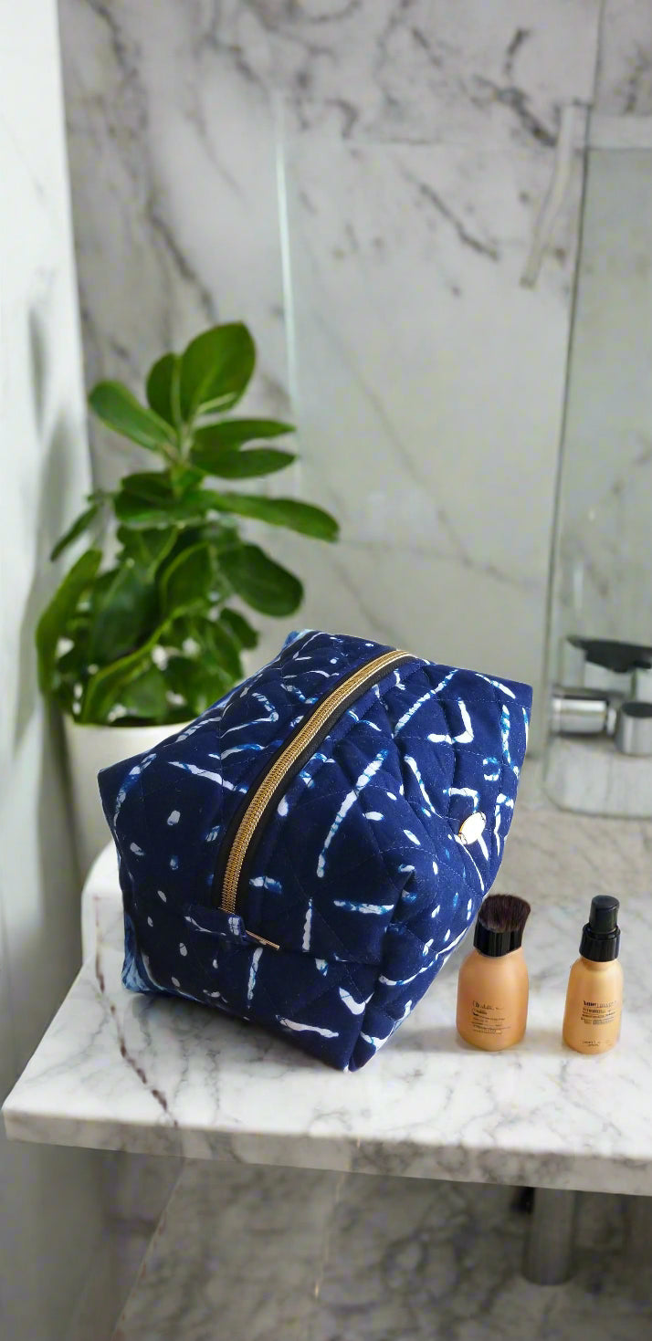 Front view of the Midnight Tribal dark blue and white makeup bag by Scope and Flow on a marble vanity.