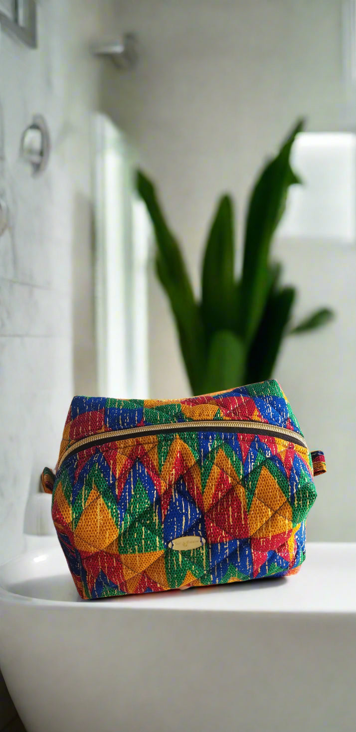 Close-up detail of the vibrant blue and red geometric tribal print on the Scope and Flow makeup bag.
