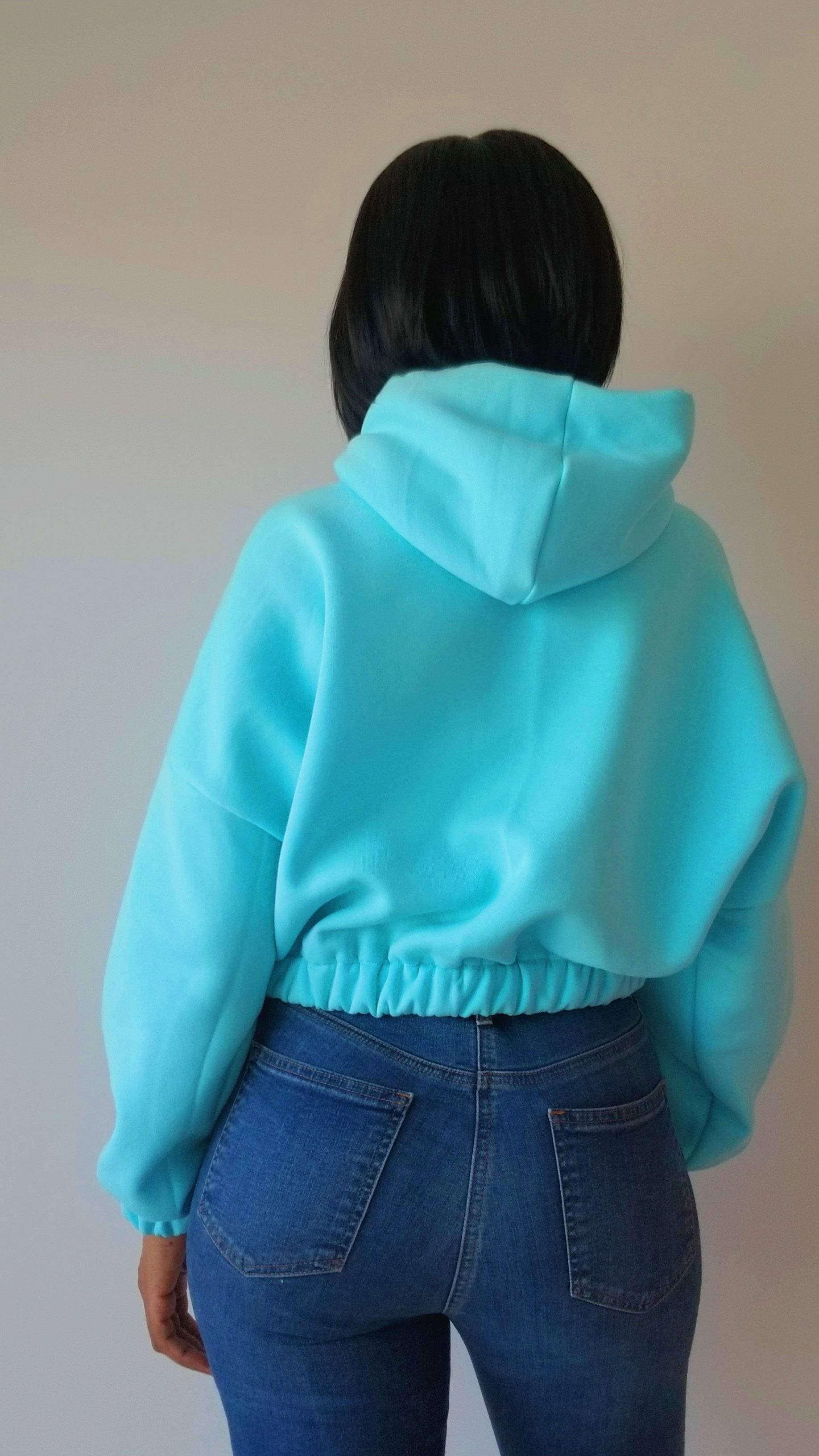 the back of a woman wearing a blue hoodie