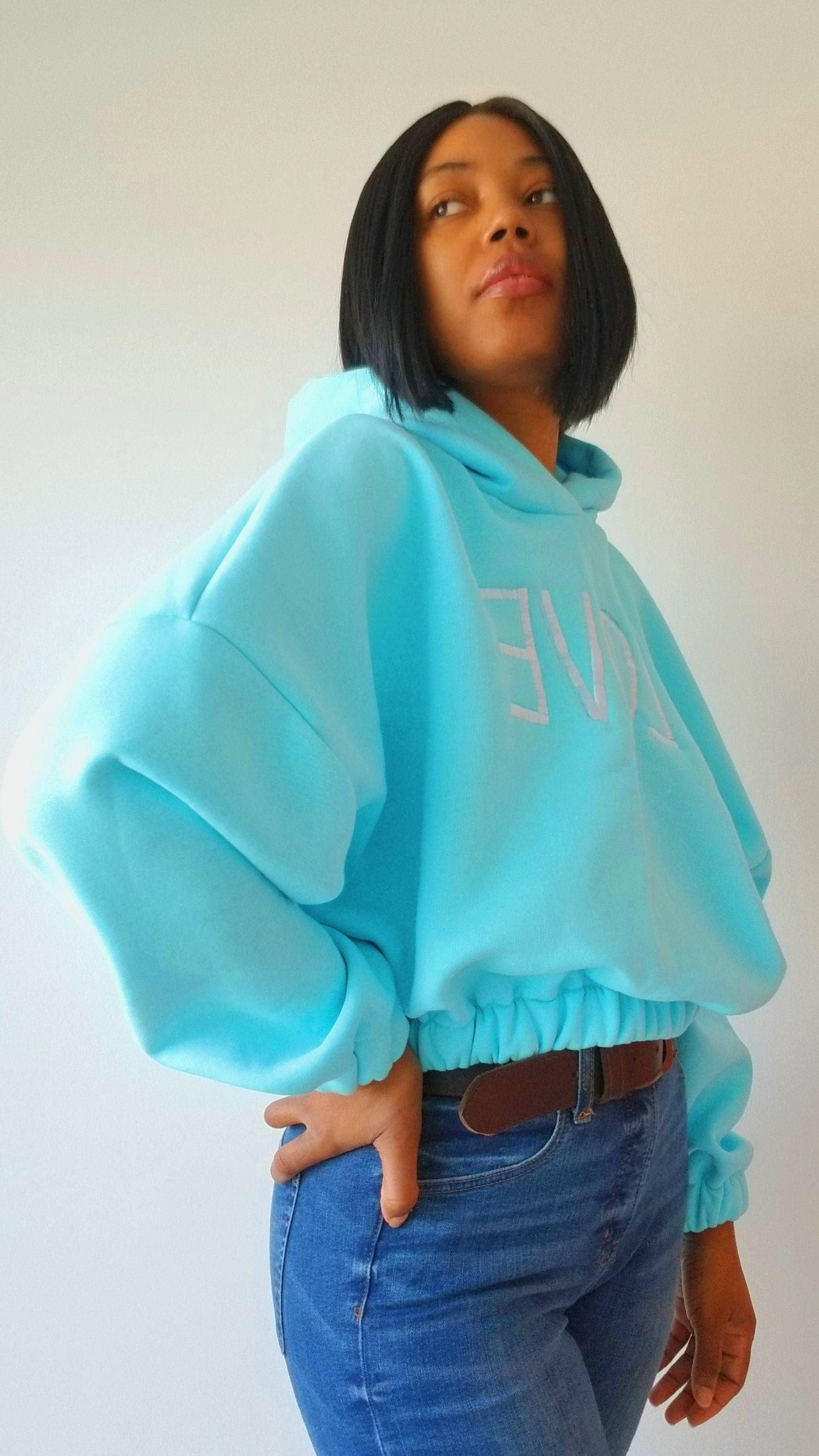 a woman wearing a blue sweatshirt with the word love on it