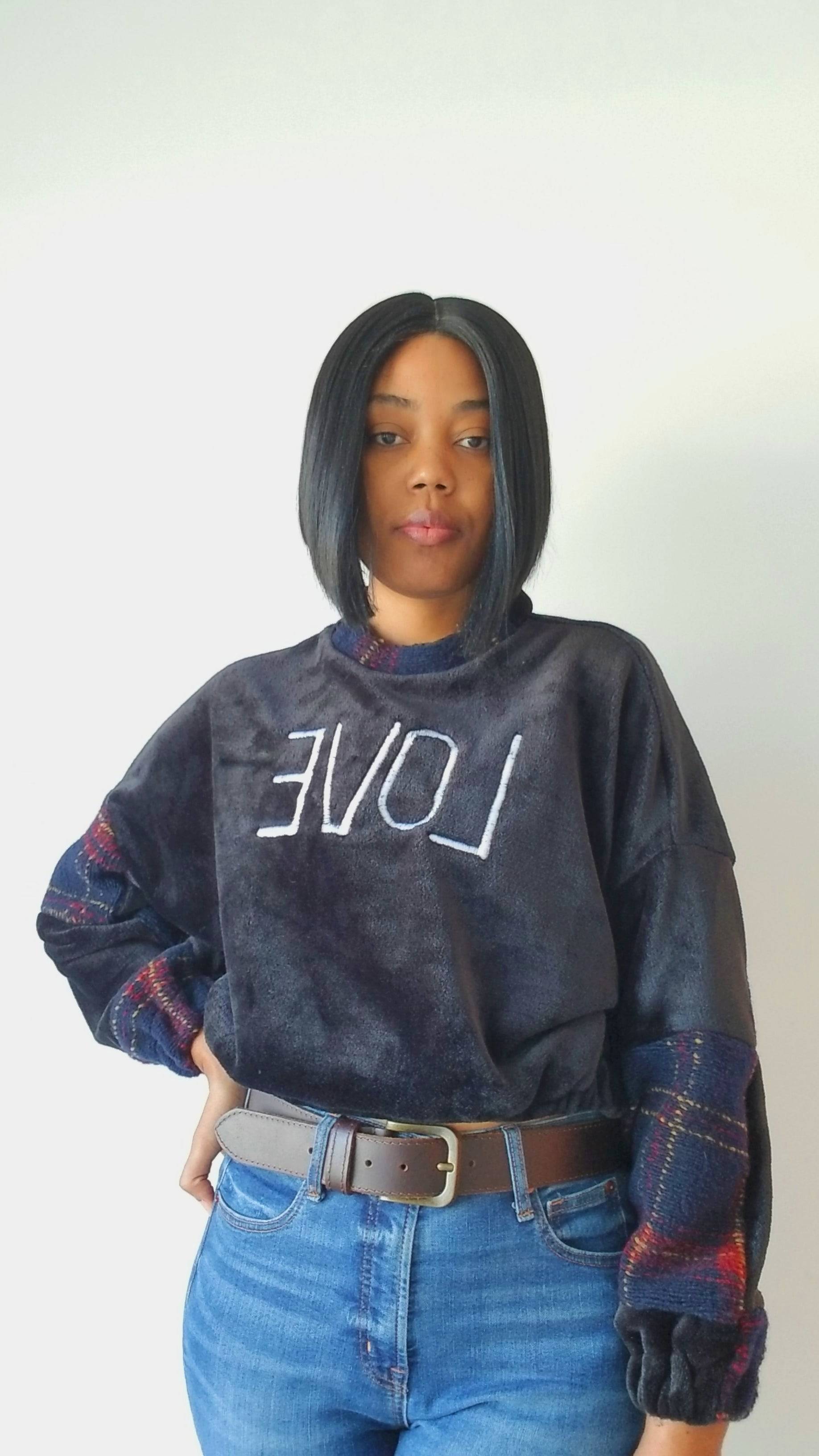 a woman wearing a black sweatshirt with the word love on it