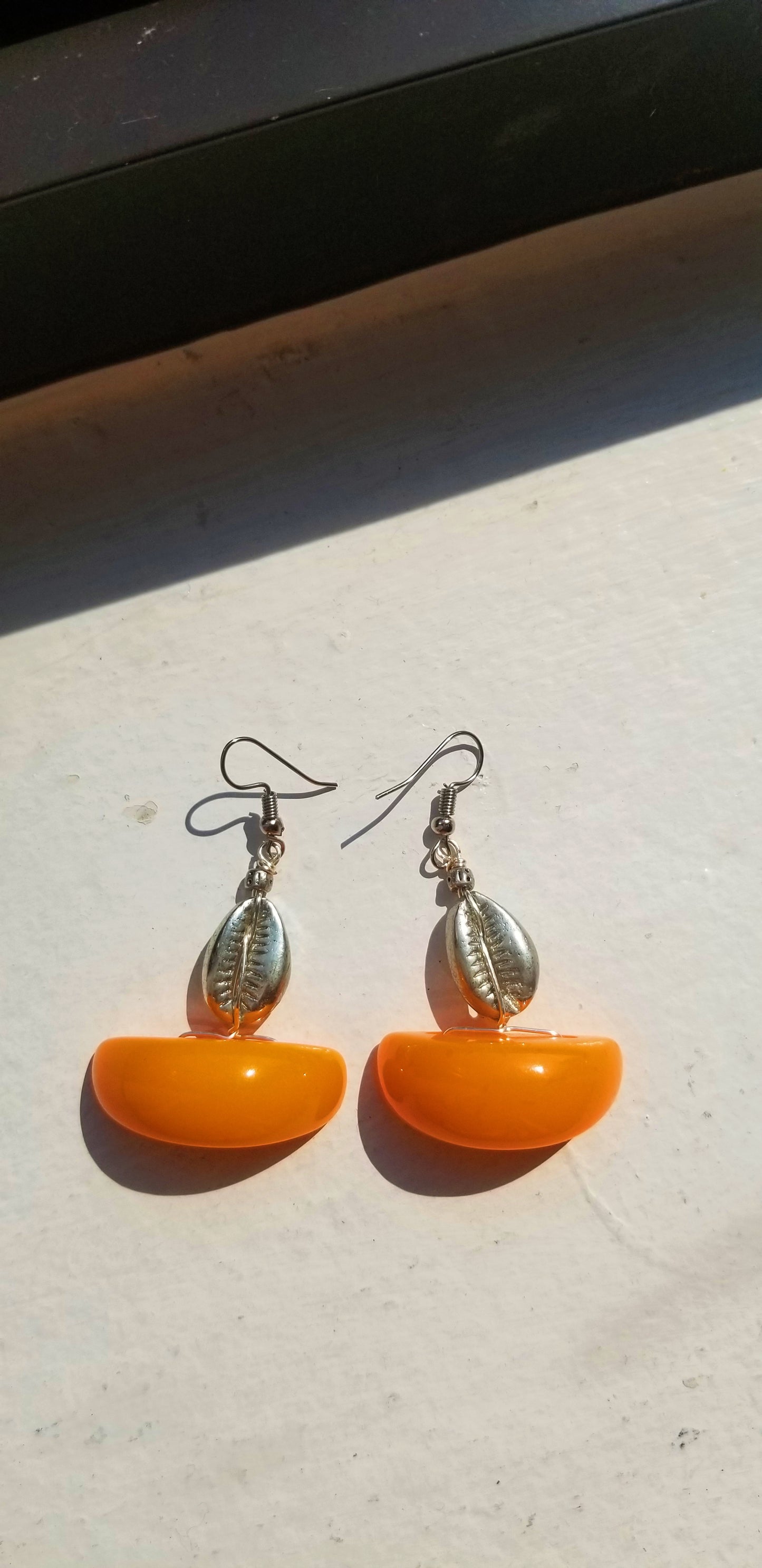 Minimalist Amber resin half-moon earrings with organic hand-selected cowrie shell accents.